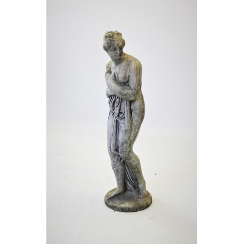 930 - A reconstituted stone garden statue, modelled as a scantily clad classical female figure, upon a cir... 