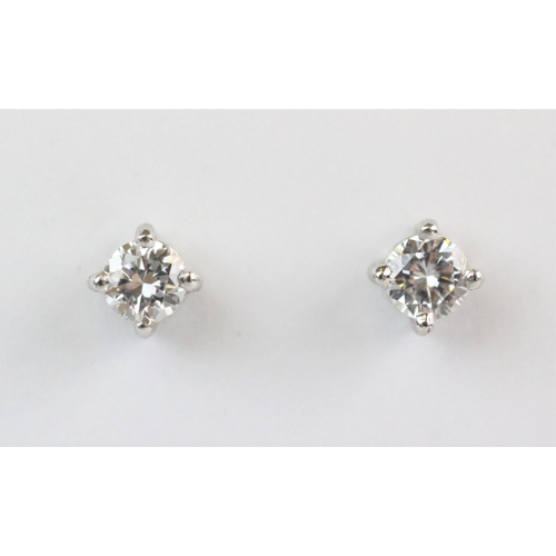 154 - A pair of diamond solitaire stud earrings, each set with a brilliant cut diamond measuring approx 0.... 