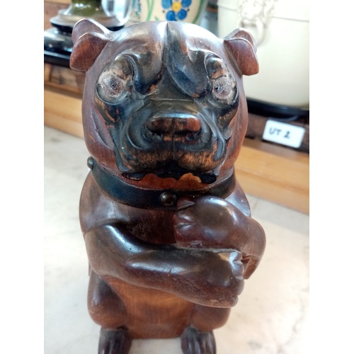 214 - A treen tobacco jar in the form of a dog, 19th century, the seated dog modelled with arms crossed to... 