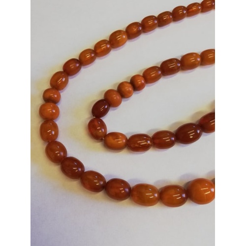 134 - A 'Butterscotch' amber single strand bead necklace, the sixty-nine graduated beads (largest measurin... 