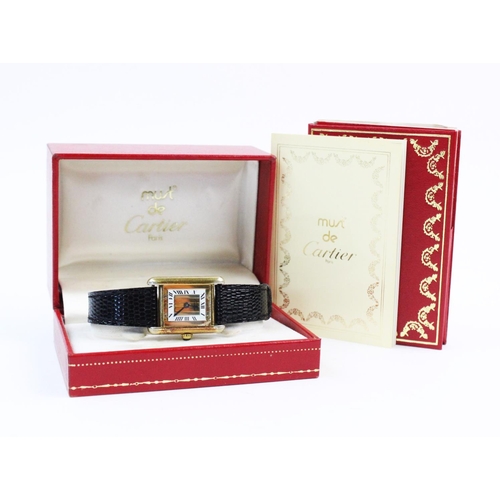 132 - A lady's silver gilt Must de Cartier Tank wristwatch, the three colour gold striped rectangular dial... 