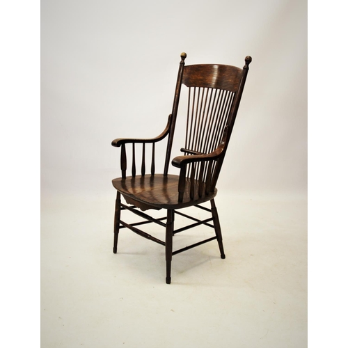 863 - A 19th century American style oak elbow chair, with a concave top rail above a stick back and shaped... 