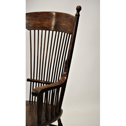 863 - A 19th century American style oak elbow chair, with a concave top rail above a stick back and shaped... 