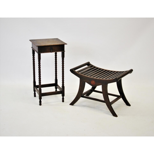 901 - An early 20th century oak luggage stand with a concave slatted top raised upon sabre legs with plain... 