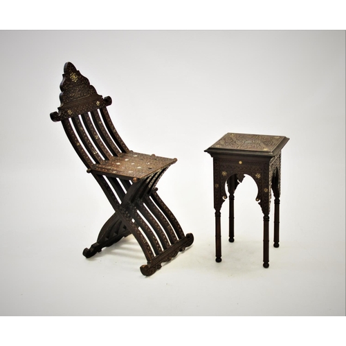 905 - An early 20th century Syrian hardwood folding chair, of articulated form with carved scroll detail a... 