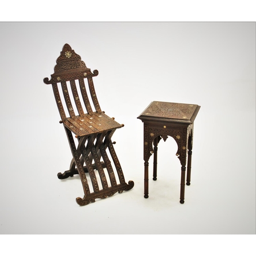 905 - An early 20th century Syrian hardwood folding chair, of articulated form with carved scroll detail a... 