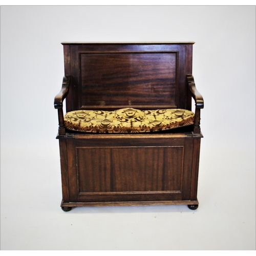 914 - An early 20th century mahogany box settle, with a panelled back above down swept arms and a hinged b... 