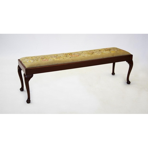 915 - A 20th century mahogany long foot stool, the rectangular needlework upholstered seat raised upon sle... 