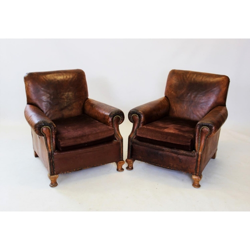 918 - An early 20th century tan leather three piece lounge suite, the two seater settee with padded scroll... 