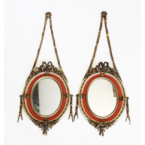 906 - A pair of early 20th century French gilt wood pendent wall mirrors, the oval mirrored plates within ... 