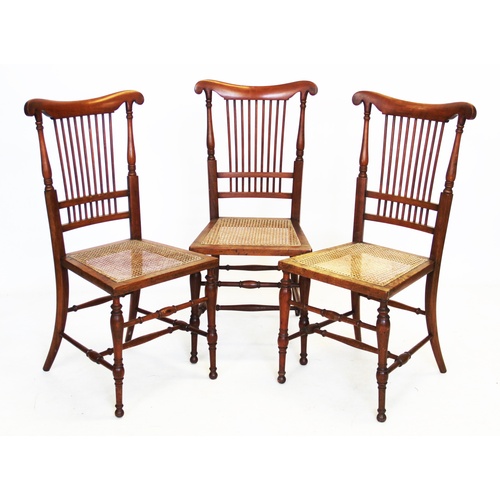 880 - A set of three Victorian walnut bedroom chairs, each with a comb back above a rattan seat, upon turn... 