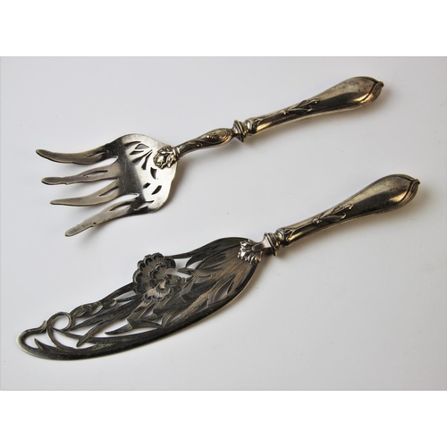 128 - A pair of continental Art Nouveau fish servers, each finely pierced with pinks and scrolling foliage... 