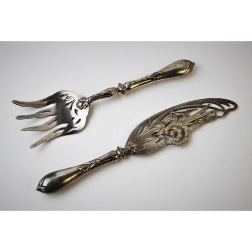 128 - A pair of continental Art Nouveau fish servers, each finely pierced with pinks and scrolling foliage... 