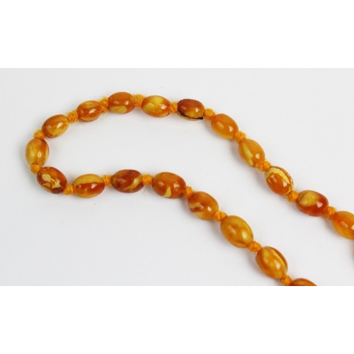 174 - A butterscotch amber necklace, designed as a single strand of fifty six graduated beads, gross weigh... 