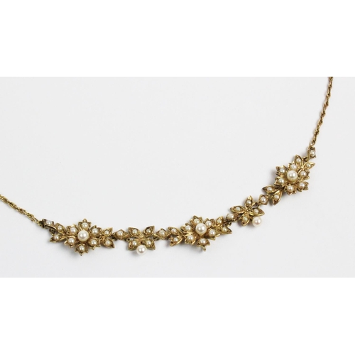 178 - A Victorian style 9ct gold and split seed pearl set necklace, designed as three floral clusters, joi... 