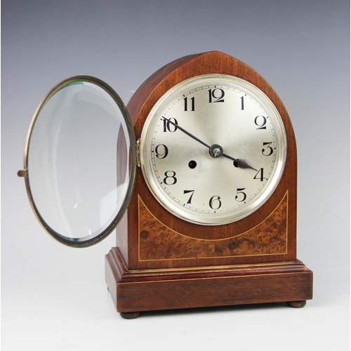 360 - A 1920's Kienzle mahogany cased bracket clock, of lancet form with an 18cm silvered dial applied wit... 