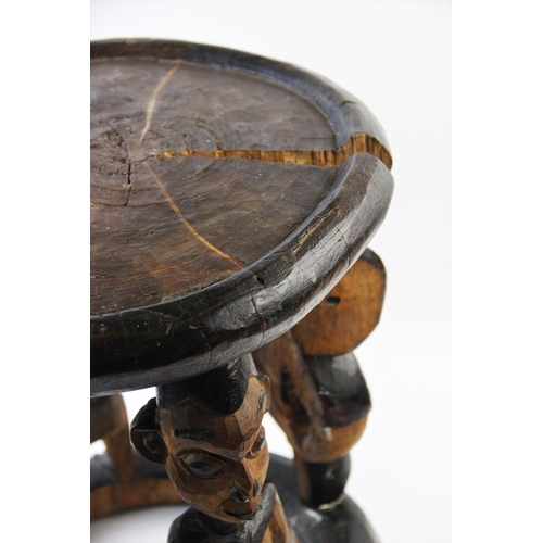 408 - A Nigerian Yoruba tribal stool, of circular form, designed with four figural legs, alternating Ibeji... 