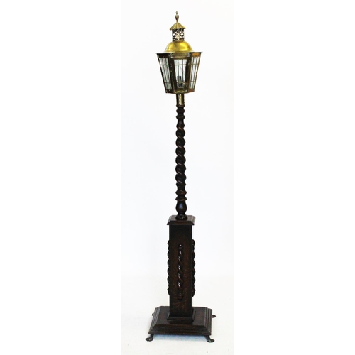 525 - A 1920's oak standard lamp, with a brass lantern type shade of hexagonal tapering form, upon a oak b... 