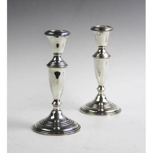 69 - A pair of 'Empire Sterling' candlesticks, each of baluster form and raised on tapering circular base... 