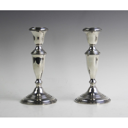 69 - A pair of 'Empire Sterling' candlesticks, each of baluster form and raised on tapering circular base... 