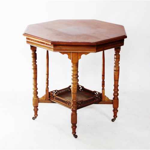 760 - An Edwardian walnut octagonal centre table, the moulded top above a galleried under shelf, raised up... 