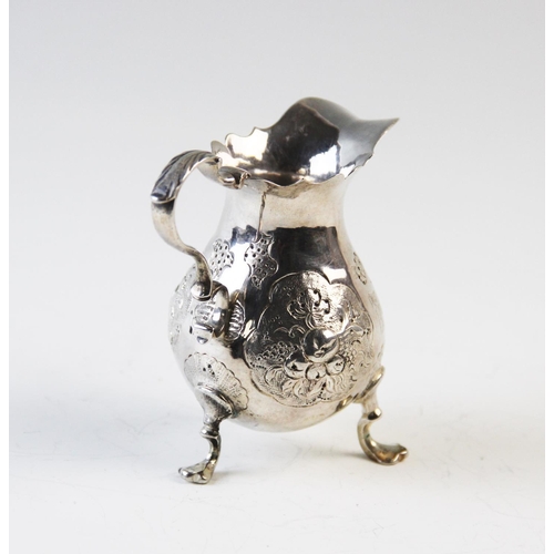 112 - A George II silver milk jug, William Coles London 1744, of typical form with three scroll legs with ... 