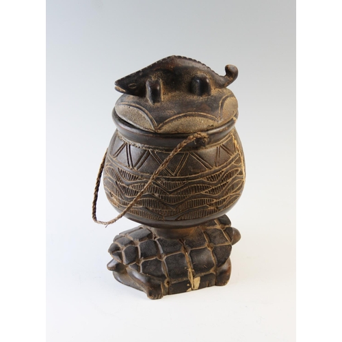 411 - A carved zoomorphic Ashanti container and cover, the removable cover with a carved crocodile finial,... 