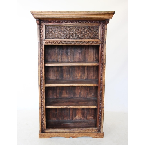 421 - An Indian carved hardwood open bookcase, the deep frieze carved with stylised flower heads above fou... 