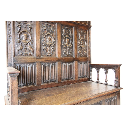 713 - A late Victorian carved oak box settle, in the 17th century style, the high back with four panels ea... 