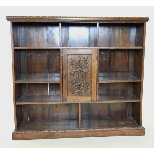 716 - A late Victorian carved oak open bookcase, the rectangular moulded top with a carved border above an... 