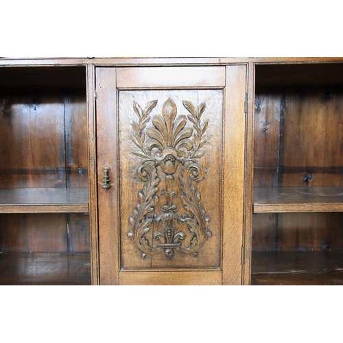 716 - A late Victorian carved oak open bookcase, the rectangular moulded top with a carved border above an... 