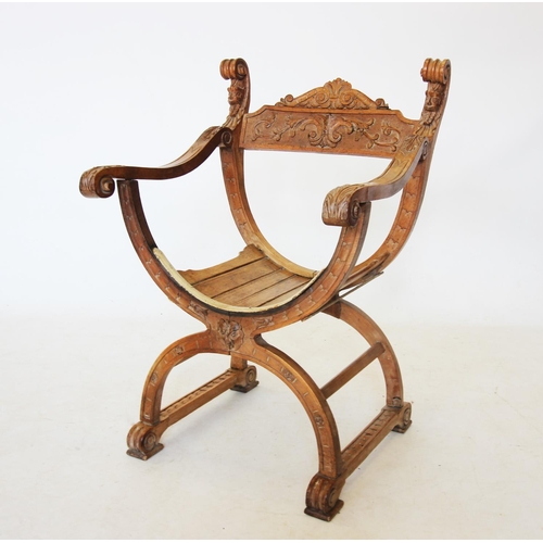 739 - A carved walnut Italian X frame chair, the top rail carved with a scrolling foliate design, flanked ... 