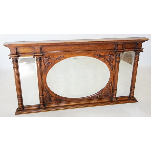 751 - An early 20th century Art Nouveau oak over mantle mirror, the central oval bevelled mirrored plate e... 