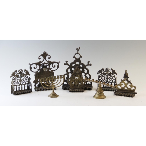 547 - A collection of Menorahs, the majority  in brass, to include free standing and wall mounted examples... 