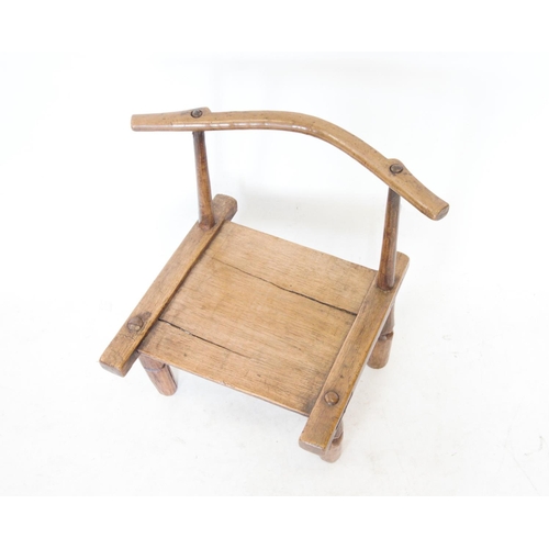 419 - A late 19th/ early 20th century primitive chair, Ivory Coast, Dan Tribe, the curved top rail on two ... 