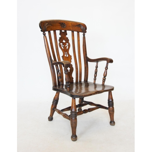 744 - A Victorian elm and beech wood Windsor elbow chair, the top rail carved with foliate decoration abov... 