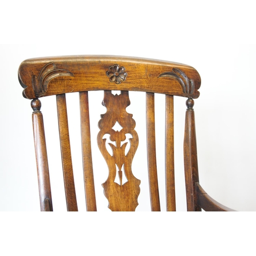 744 - A Victorian elm and beech wood Windsor elbow chair, the top rail carved with foliate decoration abov... 