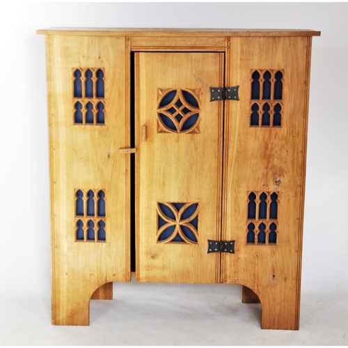 771 - A modern light oak Gothic influence side cabinet, the central door mounted with iron butterfly hinge... 