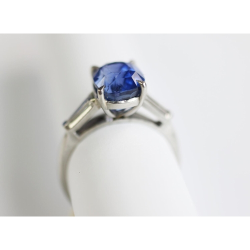 235 - A sapphire and diamond ring, the central rectangular, cushion mixed cut sapphire within a four claw ... 