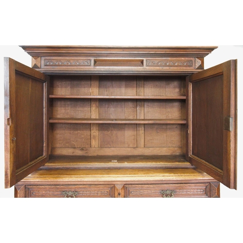 735 - A late 19th century French oak cupboard, with a moulded  and stepped cornice above a pair of cupboar... 