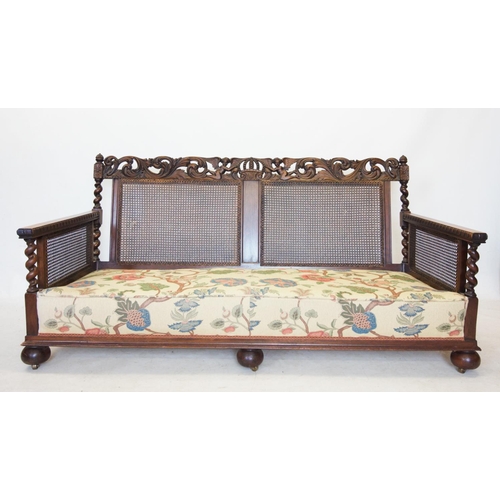 757 - An early 20th century walnut three piece bergere suite, comprising a three seater settee, with a car... 