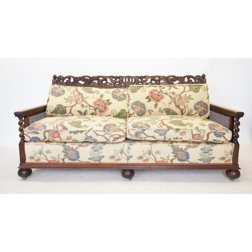 757 - An early 20th century walnut three piece bergere suite, comprising a three seater settee, with a car... 