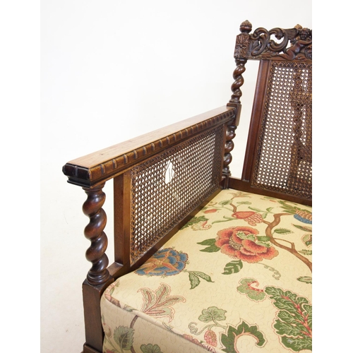 757 - An early 20th century walnut three piece bergere suite, comprising a three seater settee, with a car... 