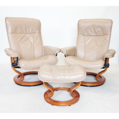 773 - A pair of taupe leather Ekornes stressless reclining armchairs, mounted upon a stained beech wood ri... 