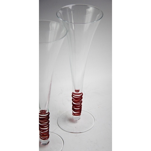 523 - A set of ten LSA champagne flutes, each clear glass with a trailed red glass stem, 24cm high (10)