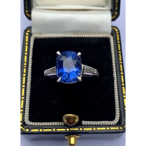 235 - A sapphire and diamond ring, the central rectangular, cushion mixed cut sapphire within a four claw ... 