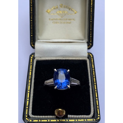 235 - A sapphire and diamond ring, the central rectangular, cushion mixed cut sapphire within a four claw ... 