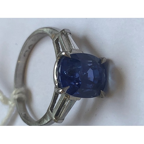 235 - A sapphire and diamond ring, the central rectangular, cushion mixed cut sapphire within a four claw ... 