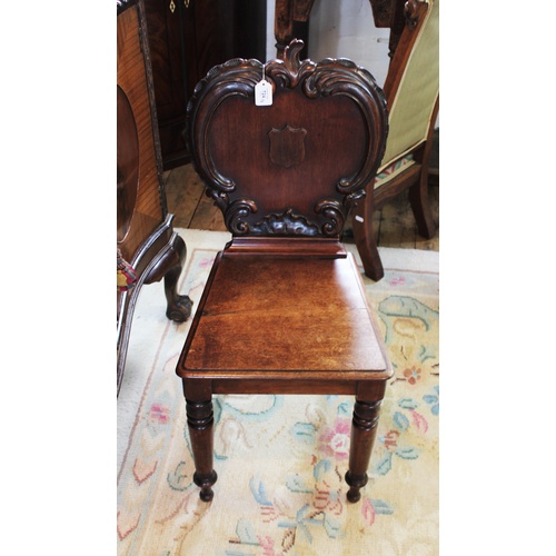 724 - A Victorian mahogany hall chair, the apple shaped back applied with 'C' scroll carving and centred w... 