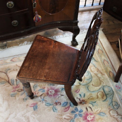 724 - A Victorian mahogany hall chair, the apple shaped back applied with 'C' scroll carving and centred w... 